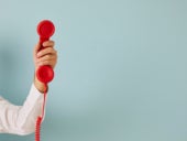 Man hand isolated on green studio background hold corded telephone.