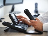 Man dialing from a telephone keypad.