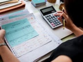 An accountant/bookkeeper reviewing payment vouchers on her desk.