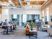 Modern office space with four people working at computers.