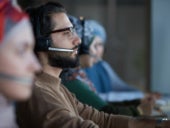 A man talking through a headset in a call center.