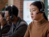 A woman talking into a headset in a call center.