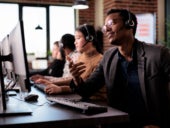 Call center employees working along a shared desk.