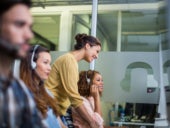 A woman assisting an agent in a call center.