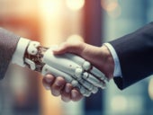 Robotic arm and businessman shaking hands.