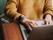 Woman using a laptop on a desk.