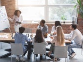 A group of individuals having a meeting about project management.