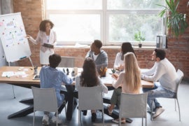 A group of individuals having a meeting about project management.