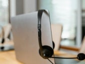 Stock photo of a headset and laptop at a call center.