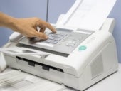 Hand pushing button on old fax machine