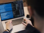 An IT professional working on a laptop.