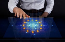 Businesswoman touching screen with the EU flag on display.