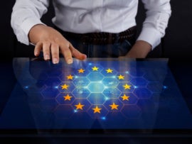 Businesswoman touching screen with the EU flag on display.