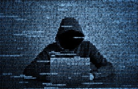 Silhouette of a hacker in hood using a laptop from numerical data.