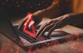 Person using laptop with virtual alert sign on top of keyboard.