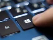 Close up of a user pressing the Windows key on a laptop keyboard.