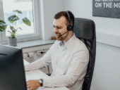 Call center agent wearing a headset and looking at their computer.