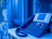 A VoIP business phone sitting on a desk.