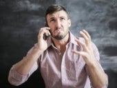 Man frustrated talking on the phone.