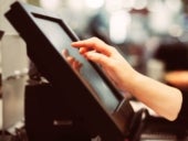 Young woman hand doing process payment on a touchscreen cash register.