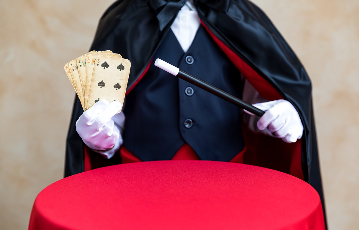 Illusionist holding magic wand and playing card.