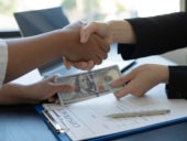 An agent handing out cash loan for client.