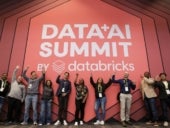 A group of people raising hands for the DATA+AI Summit by Databricks.