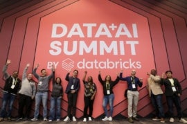 A group of people raising hands for the DATA+AI Summit by Databricks.