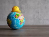 Hard hat on top of world globe.