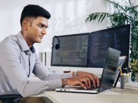 Programmer typing on laptop.