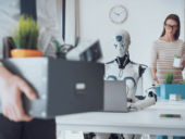 Robot working on laptop in an office
