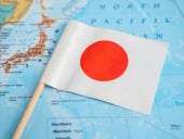 Japan flag on world map background.