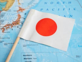 Japan flag on world map background.