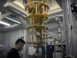 IBM researcher near quantum computer cooling system.