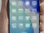 During Apple's WWDC 2025, Craig Federighi, SVP Software Engineering, holds an iPhone showing the new transparent effect on icons in iOS 26.