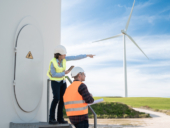 People working at sustainable alternative farm with turbine on background.