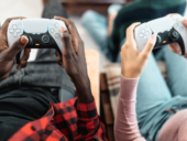 Top view of young multiracial teenagers playing online video game console at home