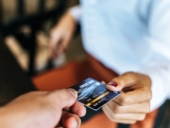 Woman submitting credit card to pay for goods