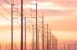 Silhouette row of electric poles against orange cloud with golden sunlight on sunset sky background