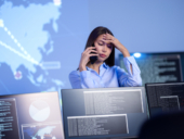 A female cybersecurity officer having an issue with the system and calling someone in the phone.