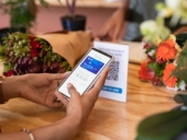 Woman paying florist using mobile phone application to scan QR code