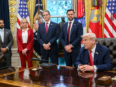 President Trump in the oval office with his staff.