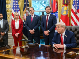 President Trump in the oval office with his staff.