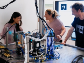 Researchers Jiaqi Chu, Francesca Parmigiani, and James Clegg with the current model of Microsoft Research’s analog optical computer in Cambridge, UK.