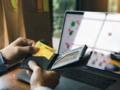 A man pulling out his credit card from his wallet for online payment transaction.