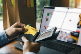 A man pulling out his credit card from his wallet for online payment transaction.