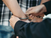 Police officer puts handcuffs on a suspect.