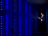 Side view of an IT technician working In the aisle of a data center Room