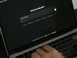 A person typing on a laptop on a table