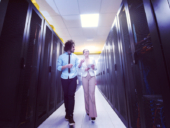 Two engineers working inside a data center.